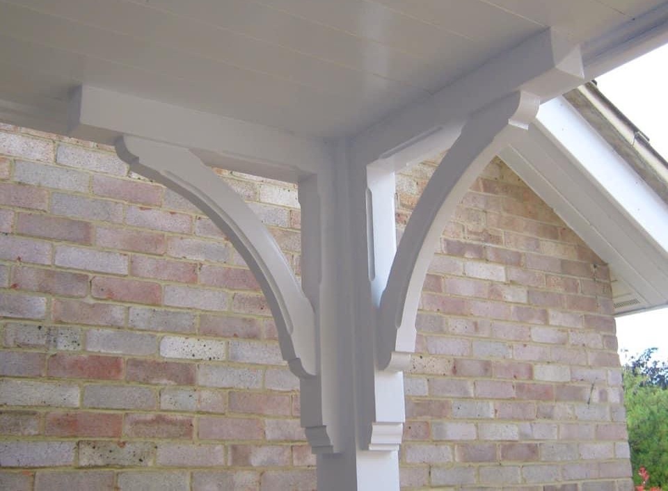 white gallows brackets fitted to decorate the eaves of this entranceway